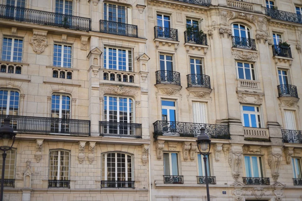 Façade d'immeuble en pierre de taille à balcons en fer forgé